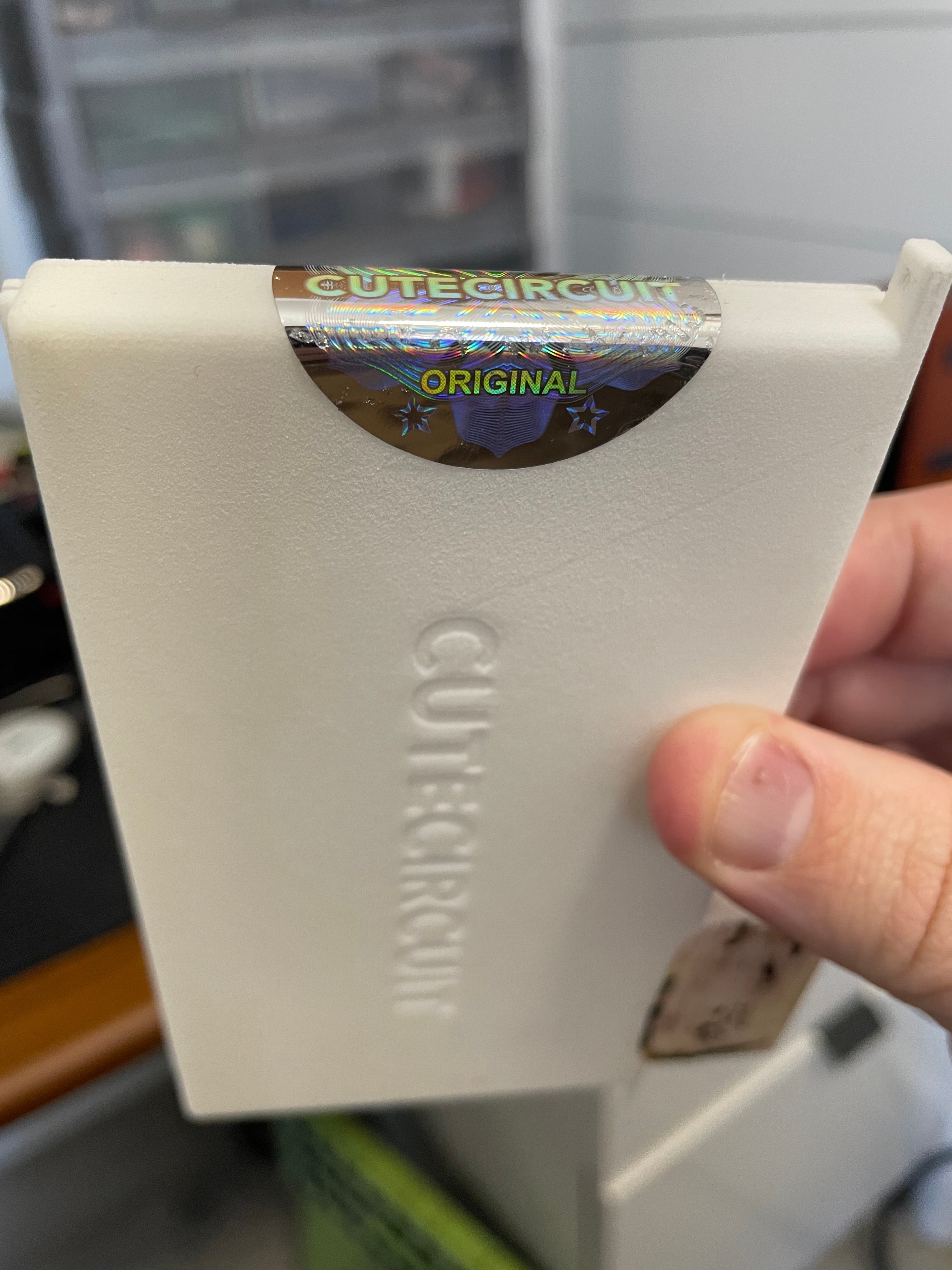 backside of the case, showing the "ORIGINAL" text on the holographic sticker and recessed CUTECIRCUIT branding