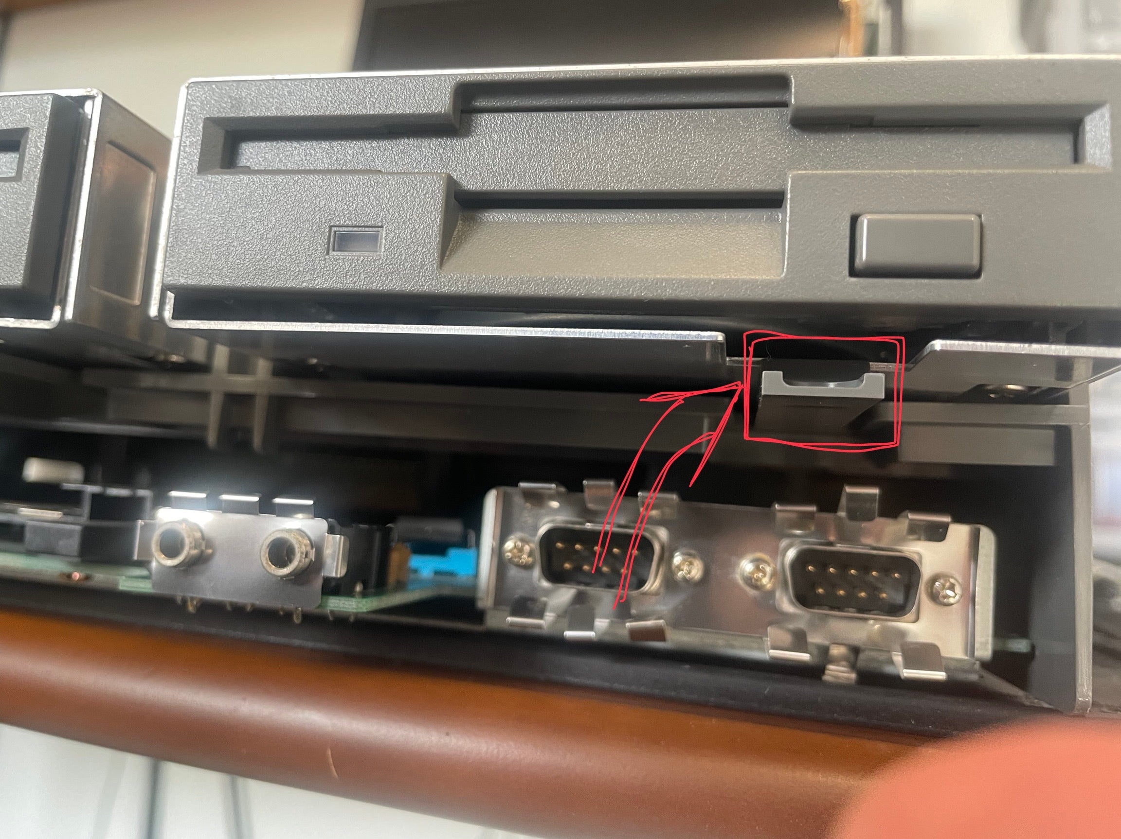 Underside of the floppy drive, highlighting the plastic tab to release it